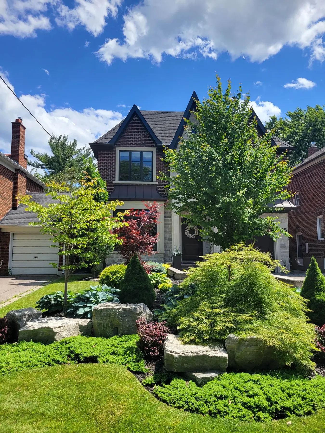 Maintained ornamental front garden with layered shrubs.